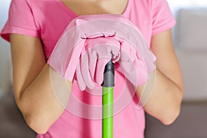 Woman in protective gloves using a wet-mop while cleaning floor