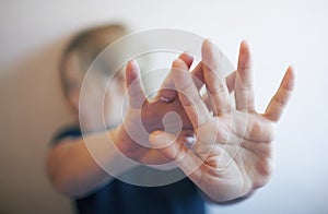 Young woman protects herself with hands from attack o