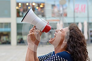 Young woman protester shouting into a megaphone