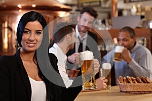 Young woman in pub with mug of beer