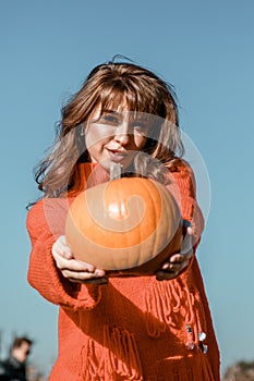 Young woman on a pumpkin farm. Beautiful girl near pumpkins. A girl with a pumpkin. Pumpkin Field. Europe farm