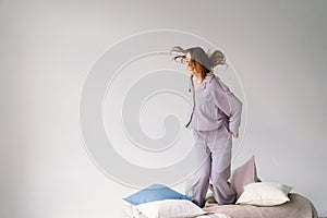 Young Woman in Purple cozy pajamas in a Play with Pillow Indoors