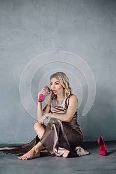 Young woman in purple dress sitting on a floor