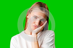 Young Woman With Pursed Lips Expressing Skepticism Against Green Screen Background