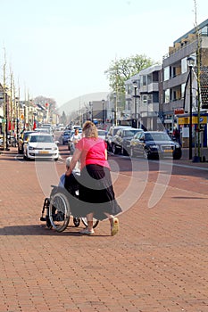 Young woman pushes on an old woman in a wheelchair, Netherlands