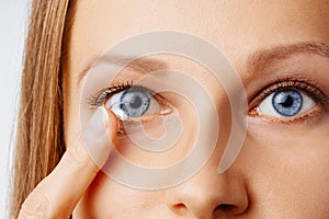 Young woman puts contact lens in her eye. Eyewear, eyesight and vision, eye care and health, ophthalmology and optometry concept