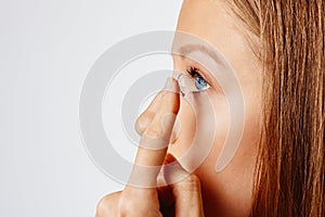 Young woman puts contact lens in her eye. Eyewear, eyesight and vision, eye care and health, ophthalmology and optometry concept