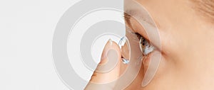 Young woman puts contact lens in her eye. Eyewear, eyesight and vision, eye care and health, ophthalmology and optometry concept,