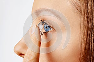 Young woman puts contact lens in her eye. Eyewear, eyesight and vision, eye care and health, ophthalmology and optometry concept