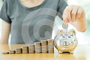 Young woman putting a coin into a money-box-close u