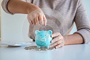 Young woman putting coins into piggy bank planning growing saving to strategy with money box for future plan fund of travel,