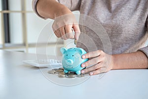 Young woman putting coins into piggy bank planning growing saving to strategy with money box for future plan fund of travel,