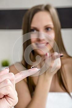 Young woman putting contact lens