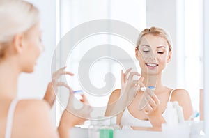 Young woman putting on contact lenses at bathroom
