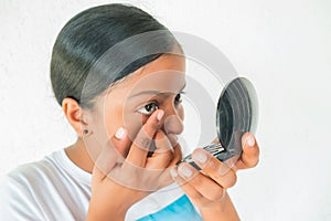 Young woman putting eye contact lense on