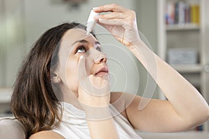 Young woman putting eye drops