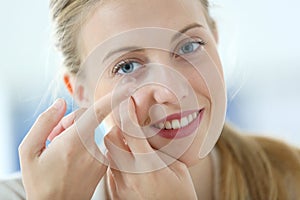 Young woman putting in eyelenses