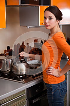 A young woman is putting a kettle