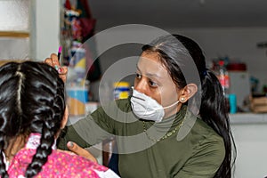 Young woman putting makeup of Catrina in a girl`s face