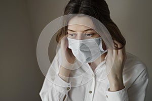 Young woman putting on a protective medical face mask. Protection from Coronavirus, covid-19