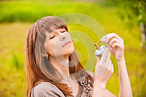 Young woman putting scent on