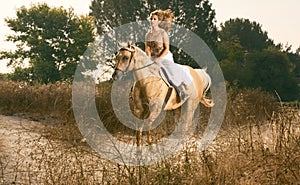 Young woman racing on horse (motion blur)