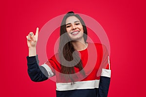 Young woman raising finger in studio