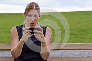 Young woman reacting in shock to an sms