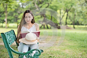 Young woman read book on chair at spring park