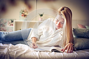 Young woman reading in bed.