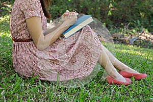 Young woman reading bible in natural park