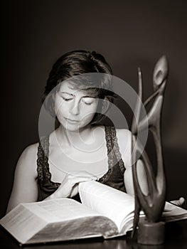 Young woman reading big book, concentration and attentiveness