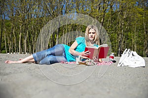 Young Woman Reading Book On Beach