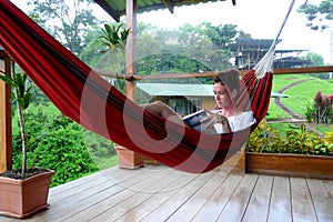 Young woman reading a book on a hammock in Fincas photo