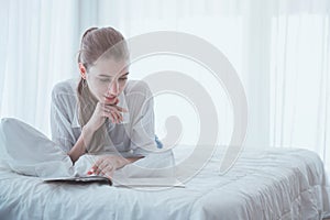 Mujer joven lectura sobre el un libro sobre el su una cama 