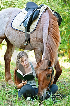 Mujer joven lectura un libro un caballo 