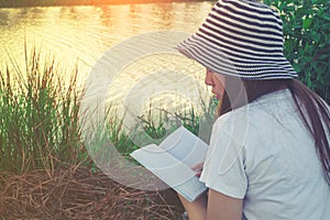 Young woman reading a book lying in relaxing at park