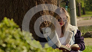 Young Woman is Reading Book in Nature