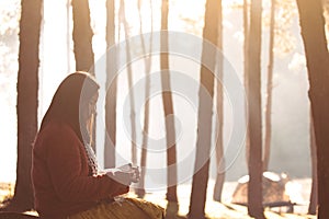 Young woman reading a book in the nature park with freshness