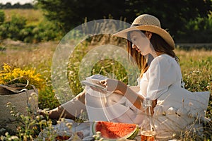 Young woman reading book in outdoor field. Reading and relaxation