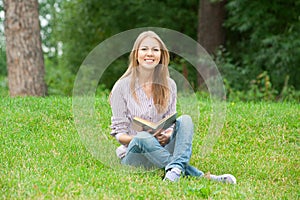 Young woman reading book outdoors