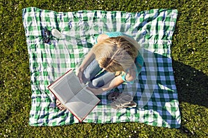 Young Woman Reading Book In Park, seen from above