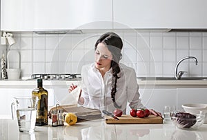 Young woman reading a cook book