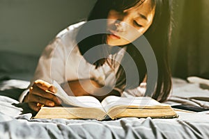 Young woman reading the holy bible in morning.