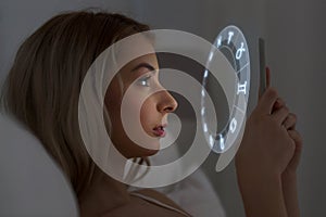 Young woman reading horoscope on smartphone