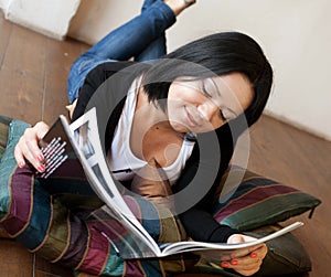 Young woman is reading the magazine