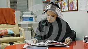 Young woman reading a magazine in a hair salon