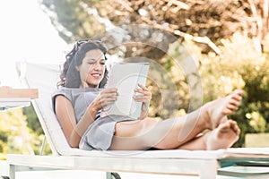 Young woman reading magazine near poolside