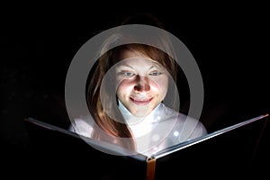 Young woman reading a magic book