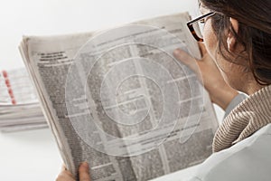 Young woman reading newspaper